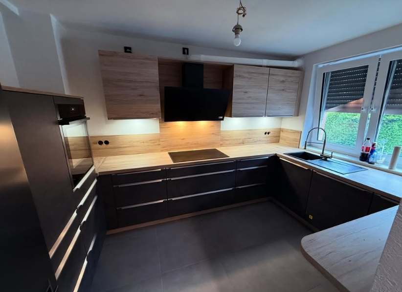 Küchenmontage — schwarze Fronten mit Holz-Rückwand